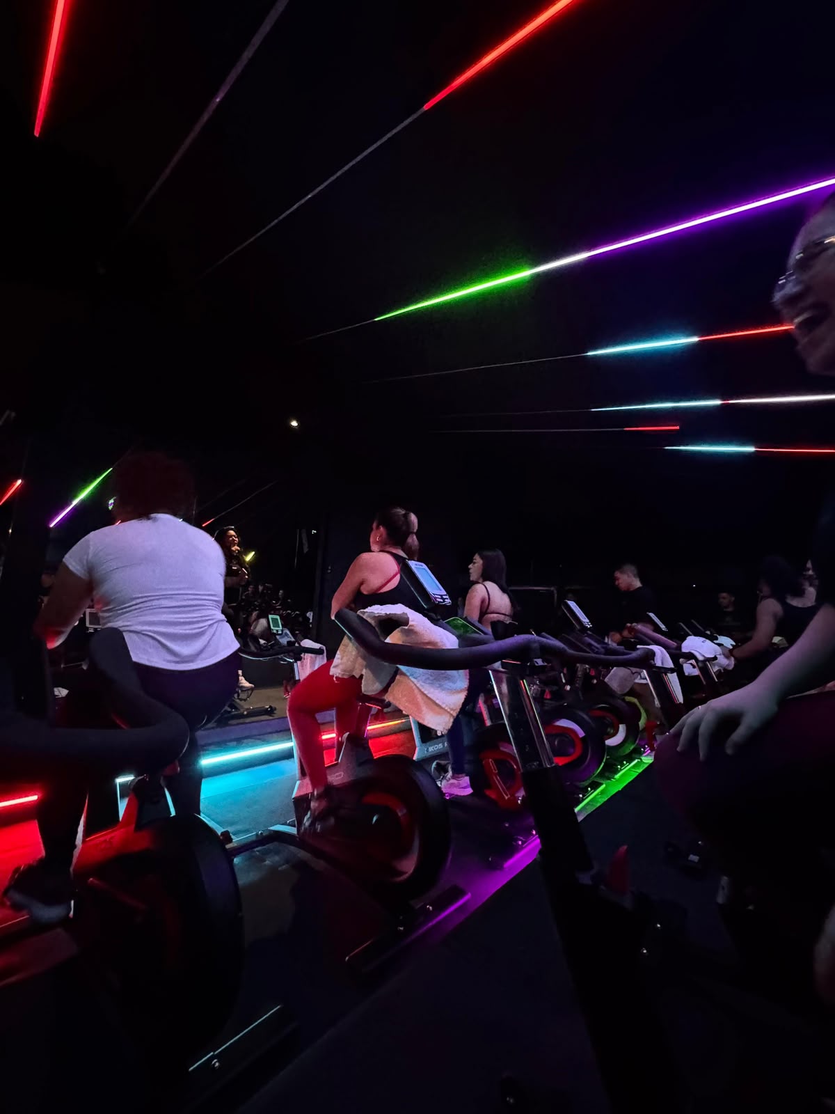 Aula de bike indoor com luzes coloridas